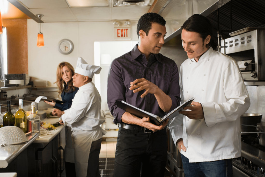 Un expert de la conformité des restaurants explique au restaurateur l'importance d'un entretien des hottes professionnelles