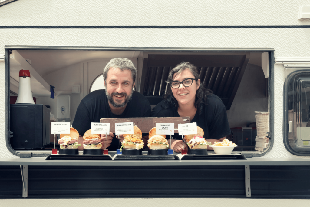 Un couple de restaurateurs après l'installation de la bonne hotte dans leur foodtruck