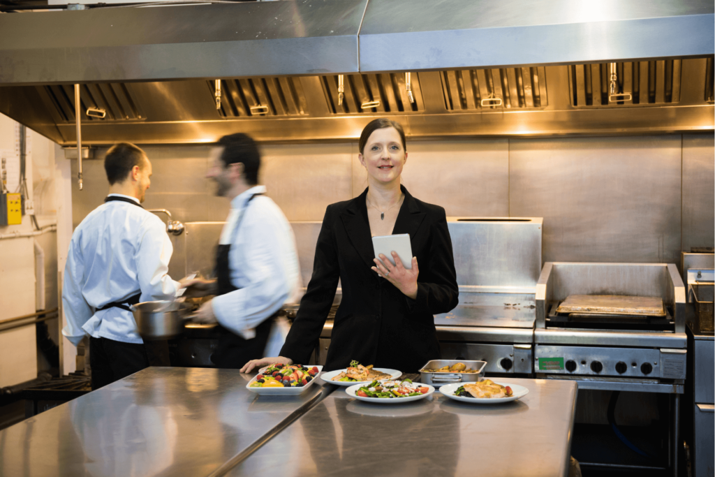 Une inspectrice vérifie que la hauteur d'une hotte de cuisine professionnelle respecte les normes nationales en vigueur